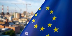 Drapeau de l'UE sur fond urbain industriel flou.