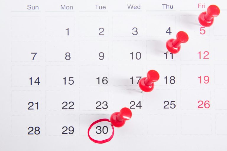 Calendrier avec punaises rouges : respecter le délai global de paiement d'un marché public