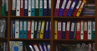 Classeurs rangés sur des étagères : les documents du marché attribué conservés par l'acheteur