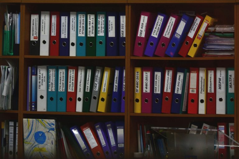 Classeurs rangés sur des étagères : les documents du marché attribué conservés par l'acheteur