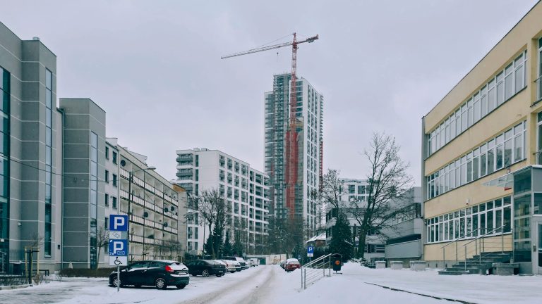 Intempéries dans un marché de travaux : chantier sous la neige avec une grue