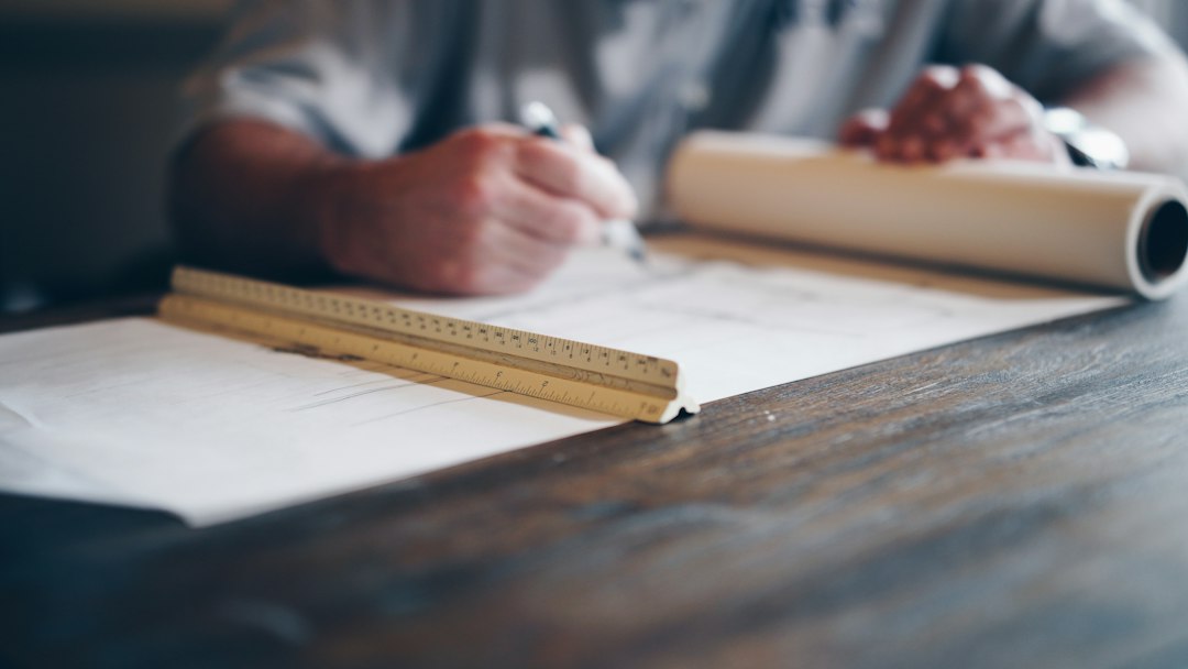Plans d'architecte sur une table pour mesurer la diminution des travaux