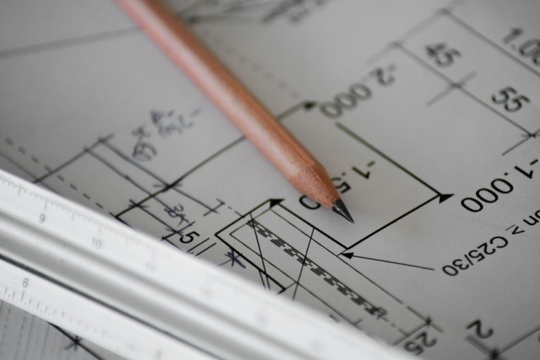 Plans et crayon pour remplir la DPGF d'un marché public de travaux